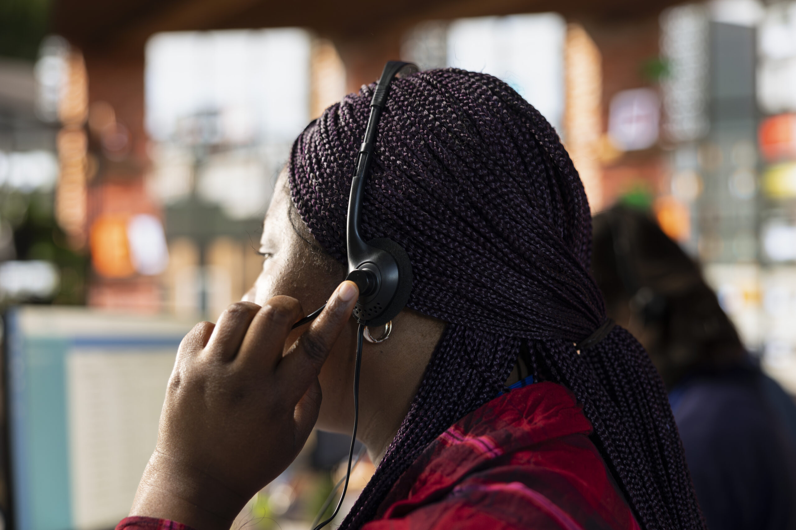 call center agent in office using headset mic to answer questions, close up